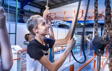 Kinder an einer Förderanlage im Museum