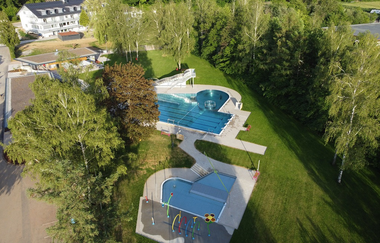 Blick von oben auf das Freibad Schwarzach mit zwei Becken und Liegewiese | © Stadt Sinsheim