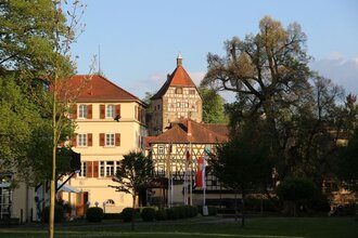 Fünfeckiger Turm mit Fachwerk neben historischem Gebäude und Baum | © Stadt Neckarbischofsheim