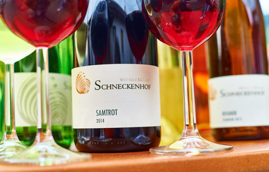 Zwei mit Rotwein gefüllte Gläser und drei Flaschen stehen auf einem Tisch | © Touristikgemeinschaft Hohenlohe e. V.