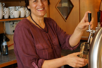 Eine Frau zapft an der Theke ein Bier | © Touristikgemeinschaft Hohenlohe e. V.