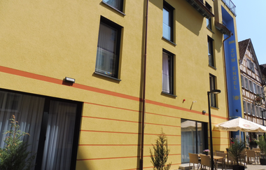 Der Gasthof von außen hat eine gelbe Fassade | © Touristikgemeinschaft Hohenlohe e. V. | Gasthof Engel