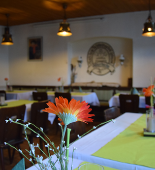 Gedeckte Tische im Gastraum mit grünen Tischdecken und Blumen | © Gasthaus zum Adler Waibstadt