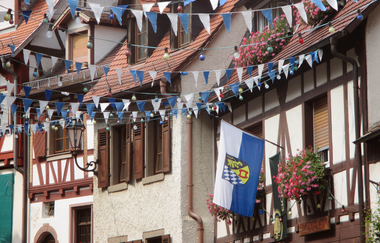 Mit blau-weißen Wimpfeln und der Stadtfahne geschmückte Fachwerkhäuser | © Maria Zimmermann