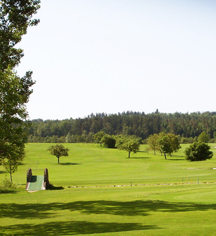 Grüner Golfplatz mit Bäumen und Wald im Hintergrund. | © Golfclub Schwäbisch Hall