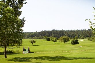 Grüner Golfplatz mit Bäumen und Wald im Hintergrund. | © Golfclub Schwäbisch Hall