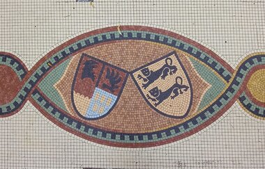 Mosaik mit zwei Wappen auf dem Kirchplatz in Gaildorf | © Petra Natzkowski