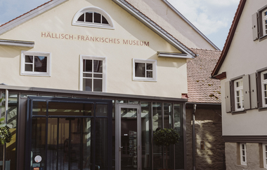Eingang des Hällisch-Fränkischen Museums in Schwäbisch Hall mit Glasfassade und historischen Gebäuden. | © Nico Kurth