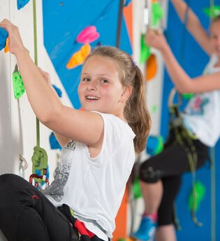 Zwei Mädchen an der Kletterwand in der Kletterhalle | © Touristikgemeinschaft Hohenlohe e.V.| Heffner Outdoor Events