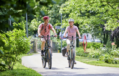 Zwei Radfahrer machen eine Radtour durch die Kreisstadt Öhringen auf geliehenen E-Bikes | © Touristikgemeinschaft Hohenlohe e.V.