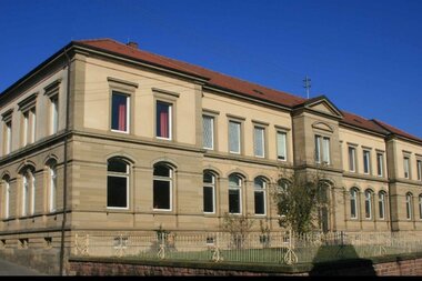 Ein klassisches doppelstöckiges Sandsteingebäude mit großen Fenstern und rotem Dach | © Gemeinde Helmstadt-Bargen