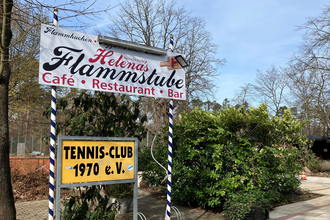 Schild der Flammstube vor den Tennisplätzen