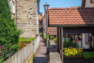 Schmaler gepflasterter Weg zwischen Häusern mit Blumen und Dekorationen. | © Stuttgart-Marketing GmbH, Achim Mende