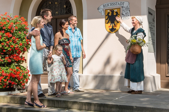 Gästeführerin im historischen Gewand mit Besuchergruppe an der Rathaustreppe | © Stadt Bad Wimpfen