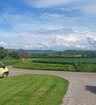 Ein gelber Transporter steht auf einer Wiese | © Touristikgemeinschaft Hohenlohe e. V. | Hofladen Fischer