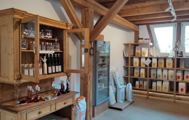 Im Schrank stehen Destillate, im Regal verschiedene Größen an Mehlpackungen | © Touristikgemeinschaft Hohenlohe e. V.