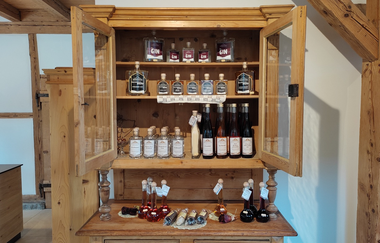 In einem alten Bauernschrank stehen Flaschen | © Hofladen Kornblume, Künzelsau-Laßbach