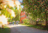 Gruppe von Menschen vor einem historischen Gebäude in Wackershofen, umgeben von blühenden Bäumen. | © © Stadt Schwäbisch Hall - Michael Kühneisen