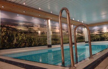 Das Schwimmbecken mit beleuchetem Weinpanorama im Hintergrund | © Touristikgemeinschaft Hohenlohe e. V.