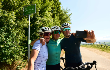Drei Gravelbiker machen ein Selfie auf einer Tour durch die Weinberge im Land der 1000 Hügel. | © Tourimia Tourismus GmbH | Stefan Leitner Photography