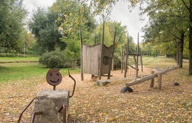 Zu sehen sind verschiedene Spielgeräte, darunter eine Wippe und ein Klettergerüst