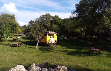 Jagsttalranch mitten in der Wiese umgeben mit grünen Bäumen und Stühlen und Tischen | © Hohenlohe + Schwäbisch Hall Tourismus e. V.