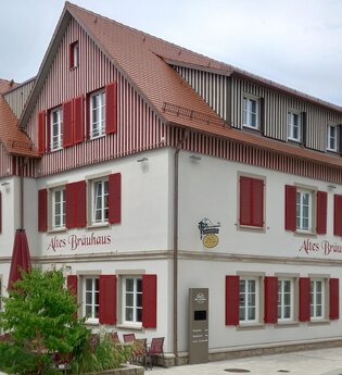 mehrstöckiges Gebäude mit rotem Dach und Fensterläden, beschriftet mit 'Altes Bräuhaus'. | © Petra Natzkowski