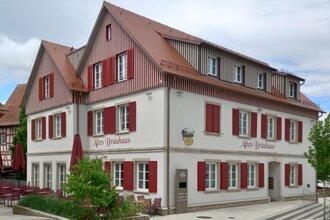 mehrstöckiges Gebäude mit rotem Dach und Fensterläden, beschriftet mit 'Altes Bräuhaus'. | © Petra Natzkowski