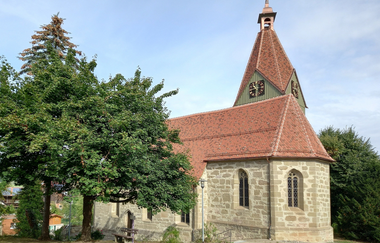 Kirche mit neuem roten Ziegeldach in Eutendorf, umgeben von Bäumen. | © Petra Natzkowski