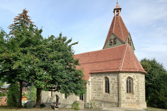 Kirche mit neuem roten Ziegeldach in Eutendorf, umgeben von Bäumen. | © Petra Natzkowski