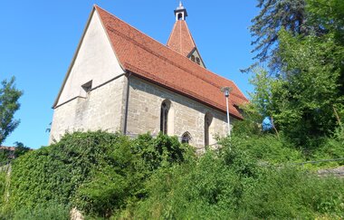 Ansicht der Kirche Sankt Kilian in Eutendorf von unten, umgeben von Bäumen und Sträuchern. | © Petra Natzkowski