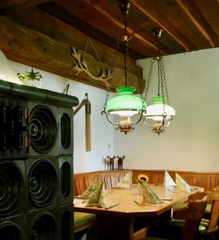 Restaurant mit Kachelofen und  gemütlicher Essecke | © Touristikgemeinschaft Hohenlohe e. V. | Landgasthof Adler
