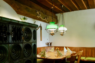 Restaurant mit Kachelofen und  gemütlicher Essecke | © Touristikgemeinschaft Hohenlohe e. V. | Landgasthof Adler