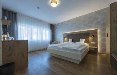 Das Zimmer mit Doppelbett ist in warmen Holztönen eingerichtet | © Touristikgemeinschaft Hohenlohe e. V. | Thomas Rathay