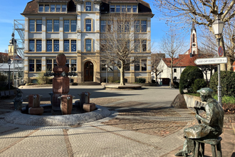Platz mit Brunnen und Gussfigur vor dem Rathaus