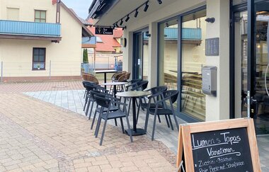 Plätze vor dem Café und Angebotstafel