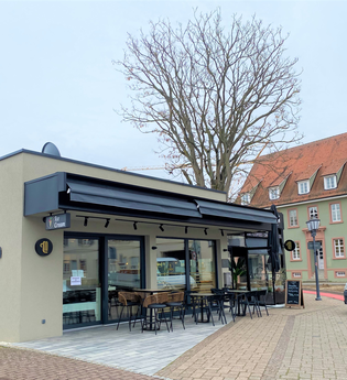 Außenansicht und Plätze vor dem Café