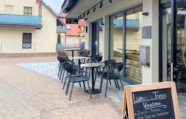 Plätze vor dem Café und Angebotstafel