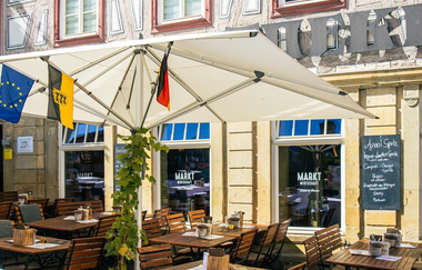 Außenbereich eines Cafés mit Sonnenschirmen und Flaggen in Besigheim. | © Stuttgart-Marketing GmbH, Sarah Schmid