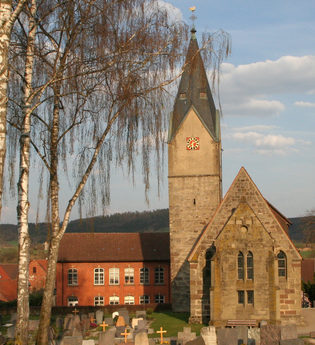 Martinskirche in Ottendorf mit Friedhof im Vordergrund und blühenden Bäumen. | © Petra Natzkowski