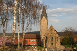 Martinskirche in Ottendorf mit Friedhof im Vordergrund und blühenden Bäumen. | © Petra Natzkowski