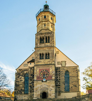 Kirche St. Michael in Schwäbisch Hall mit umliegenden Fachwerkhäusern bei Sonnenschein. | © Stuttgart-Marketing GmbH, Sarah Schmid