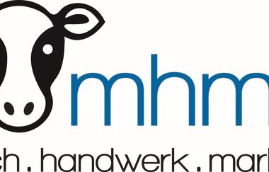 Das Logo ist ein schwarzweißer Kuhkopf mit Schriftzug mhm.... milch.handwerk.marlach. | © Touristikgemeinschaft Hohenlohe e. V. | Milchhandwerk Marlach