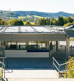 Eingangsbereich eines modernen Freibads mit grüner Umgebung und Hügeln im Hintergrund. | © Stuttgart-Marketing GmbH, Sarah Schmid