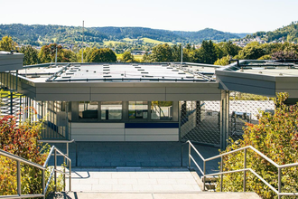 Eingangsbereich eines modernen Freibads mit grüner Umgebung und Hügeln im Hintergrund. | © Stuttgart-Marketing GmbH, Sarah Schmid