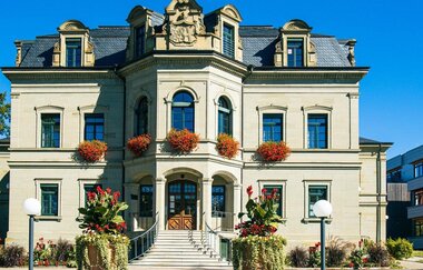 Neues Schloss in Gaildorf mit Blumen geschmückten Fenstern und moderner Architektur im Hintergrund. | © Stuttgart-Marketing GmbH, Sarah Schmid