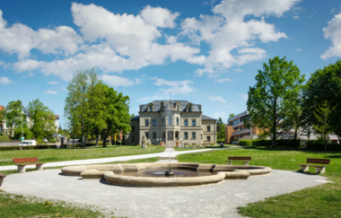 Neues Schloss in Gaildorf mit Brunnen im Vordergrund und blauem Himmel. | © Stadt Gaildorf