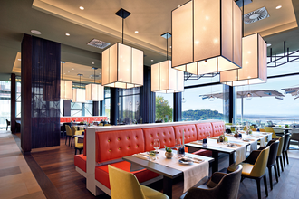 Das Restaurant ist mit roten Sitzbänken und modernen Stühlen und Leuchten ausgestattet | © Touristikgemeinschaft Hohenlohe e. V. |  Panoramahotel Waldenburg – Mellenthin