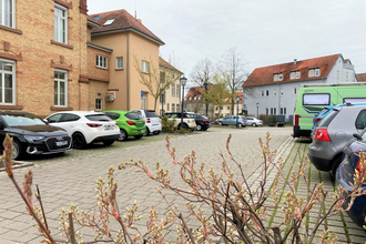 Parkplatz voller Autos vor dem Rathaus