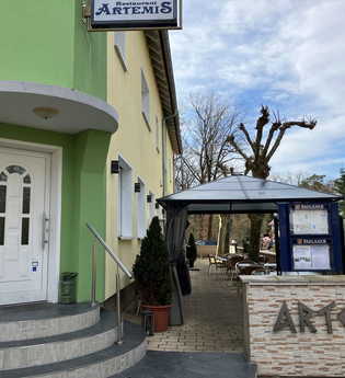 Eingang des Restaurant Artemis mit grüner Hauswand